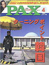 Front cover of PAX magazine, issue 4, showing a man in a dark coat in a plaza with a white domed building and yellow umbrella display; green PAX title at top.